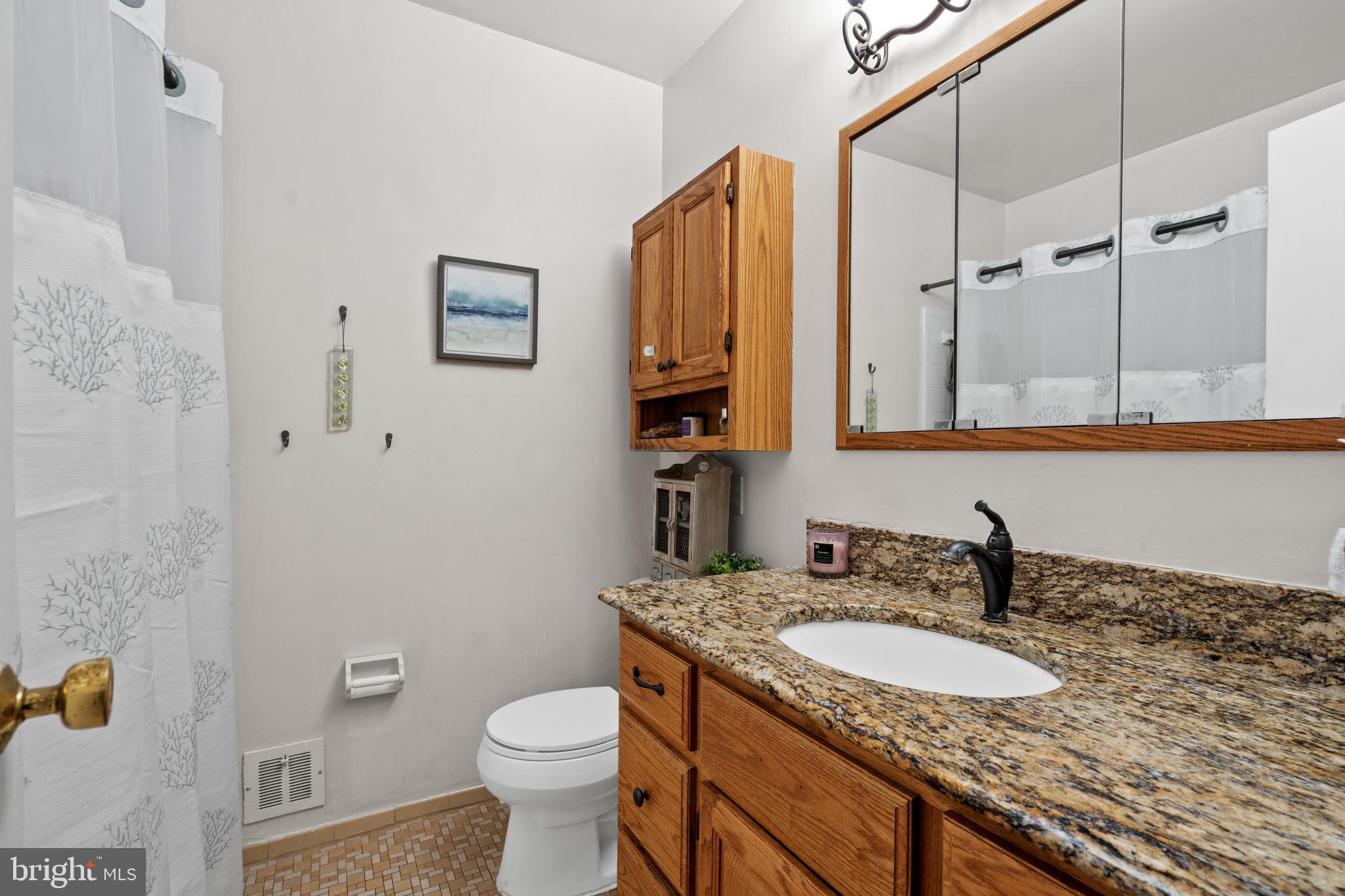 6823 Churchill Road McLean, VA 22101 - Photo 31 of 40 a bathroom with a granite countertop sink and a toilet