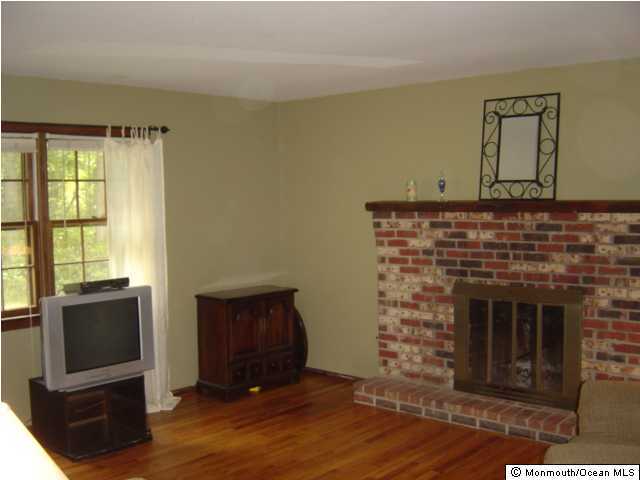 187 Frank Applegate Road Jackson, NJ 08527 - Photo 3 of 3 a living room with a fireplace and a flat screen tv