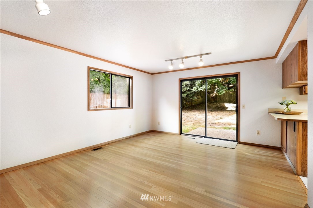 13024 Northeast 184th Place Bothell, WA 98011 - Photo 8 of 27 an empty room with wooden floor and windows