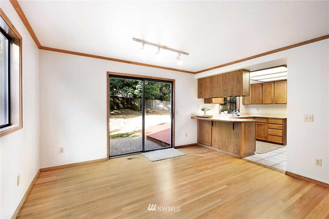 13024 Northeast 184th Place Bothell, WA 98011 - Photo 9 of 27 a kitchen with stainless steel appliances kitchen island granite countertop a refrigerator a sink a stove with wooden cabinets and floors