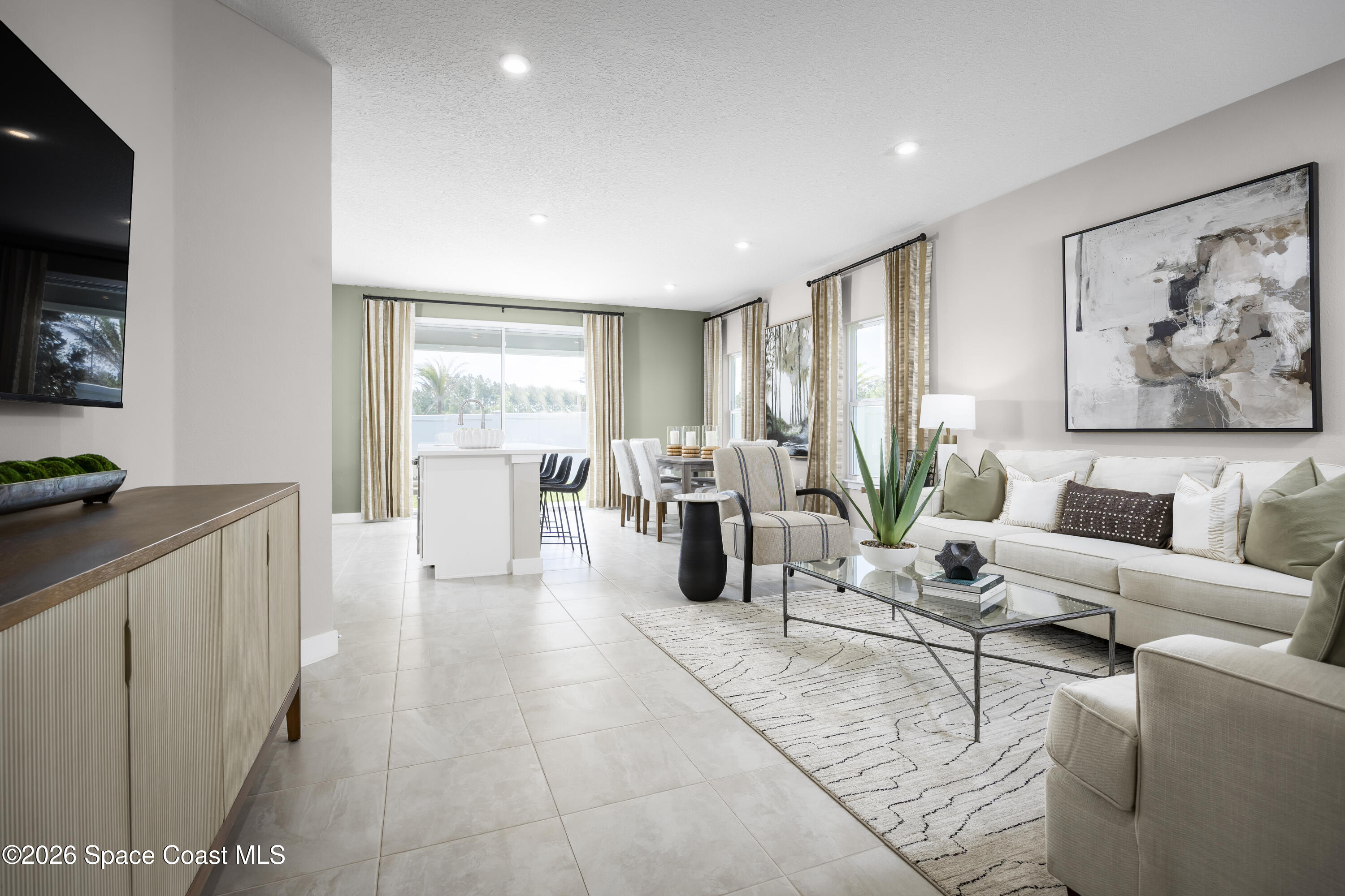1758 Kendall Pointe Place Melbourne, FL 32935 - Photo 3 of 15 a living room with furniture a flat screen tv and a large window