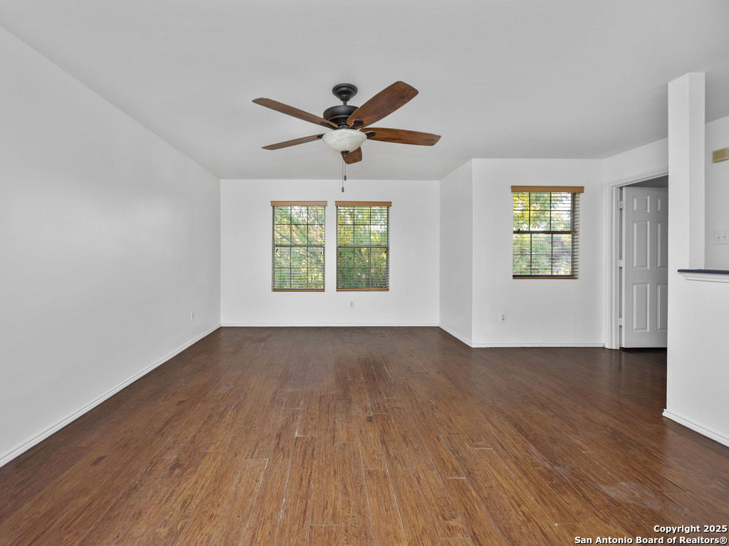 11031 Rindle Ranch San Antonio, TX 78249 - Photo 22 of 45 an empty room with wooden floor windows and ceiling fan