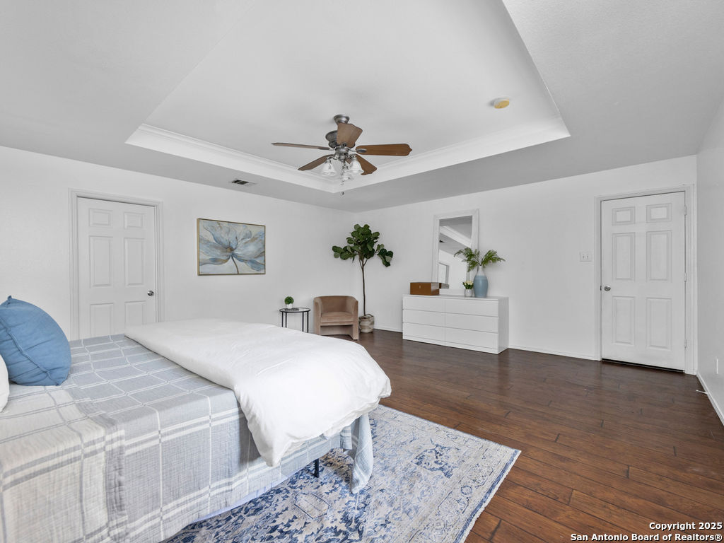 11031 Rindle Ranch San Antonio, TX 78249 - Photo 25 of 45 a spacious bedroom with a bed and a chandelier