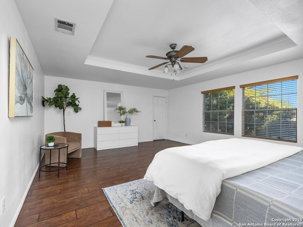 11031 Rindle Ranch San Antonio, TX 78249 - Photo 27 of 45 a spacious bedroom with a large bed and a chandelier