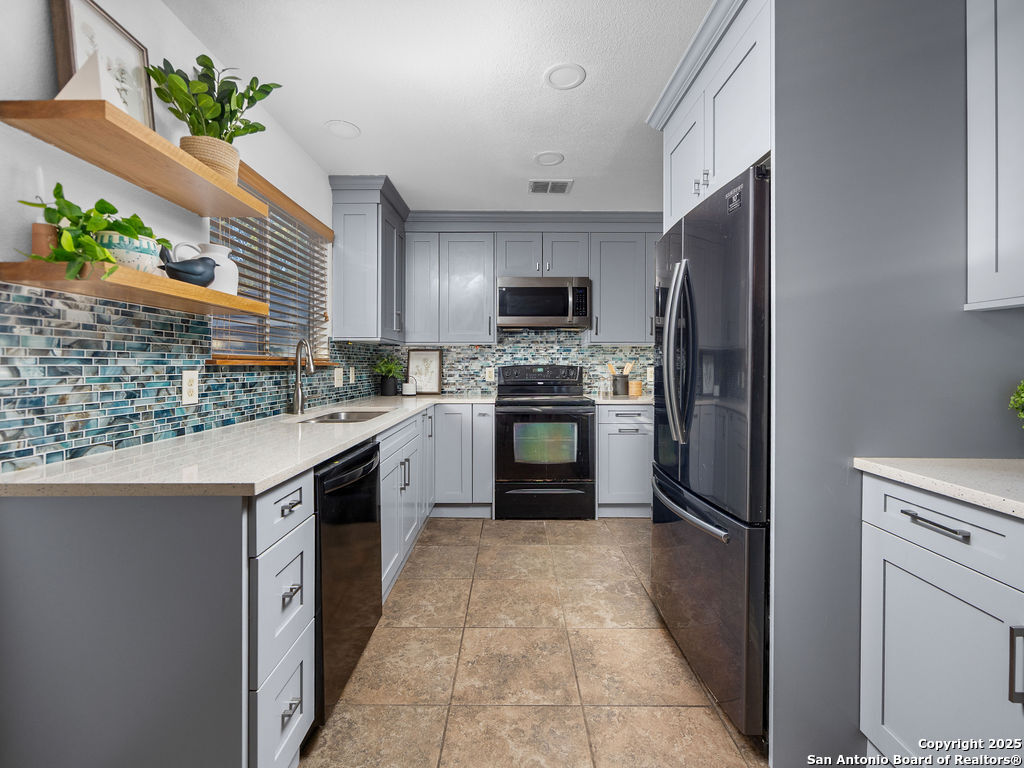 11031 Rindle Ranch San Antonio, TX 78249 - Photo 9 of 45 a kitchen with stainless steel appliances granite countertop a refrigerator a stove a sink and a microwave