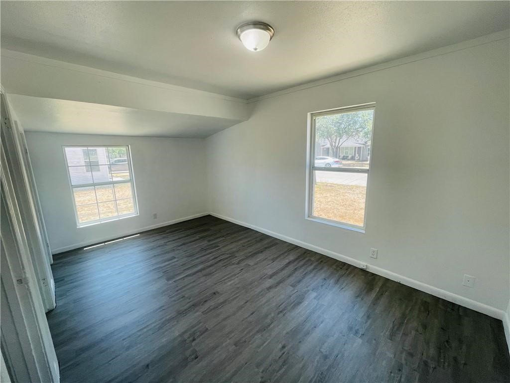 303 East Hackberry Street Mathis, TX 78368 - Photo 12 of 13 an empty room with wooden floor and windows