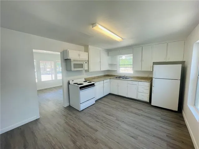 a kitchen with white cabinets and white appliances