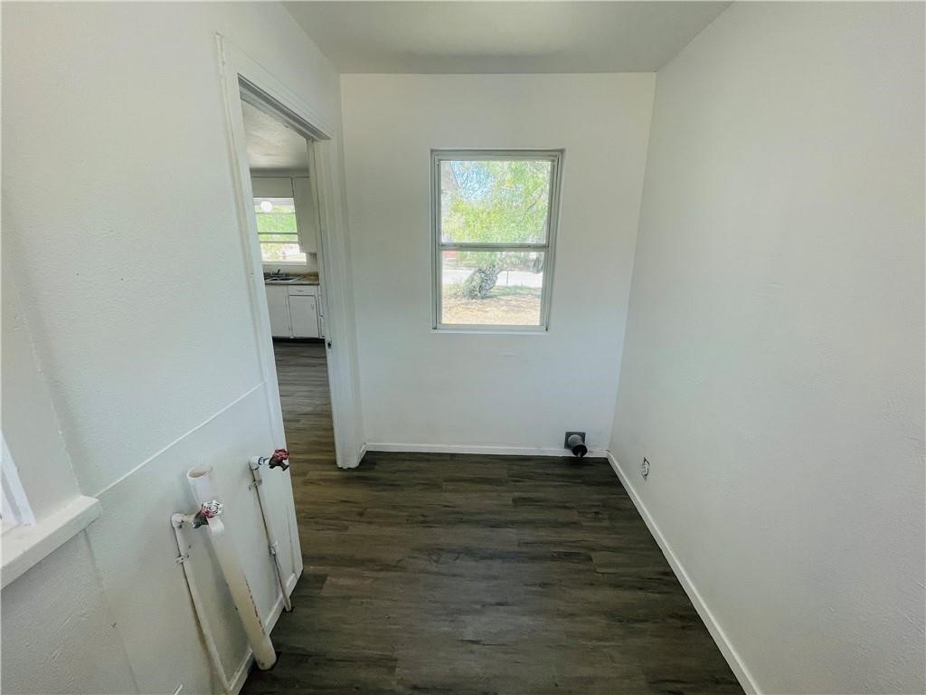 303 East Hackberry Street Mathis, TX 78368 - Photo 7 of 13 an empty room with wooden floor closet and windows