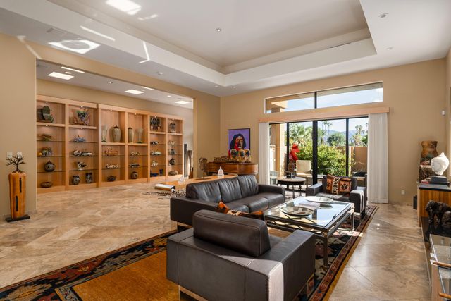 a living room with furniture large window and flat screen tv