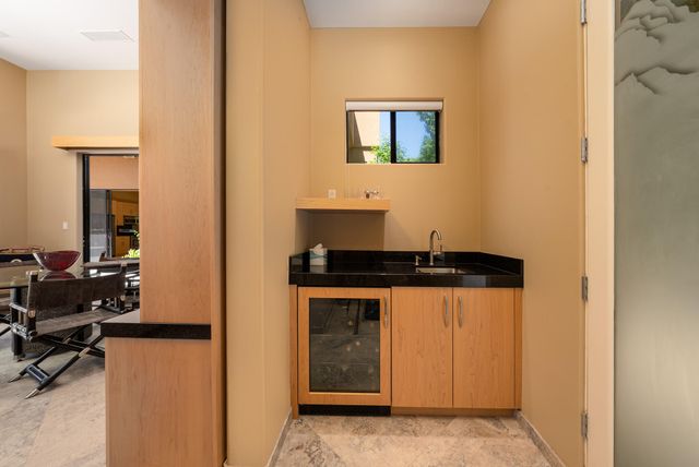 a kitchen with stainless steel appliances granite countertop a refrigerator a sink a stove and a refrigerator