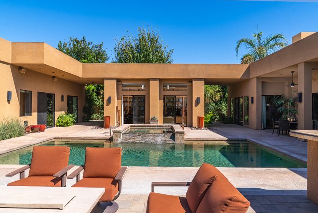a view of a house with backyard sitting area and garden