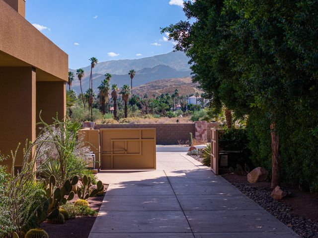 a view of a patio with couches table and chairs with wooden floor and fence