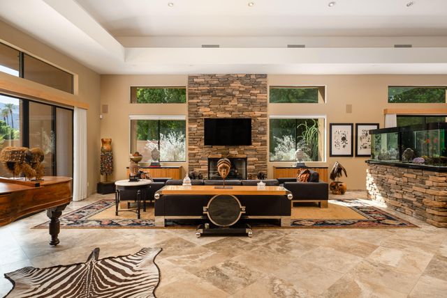 a living room with furniture a large window and a flat screen tv