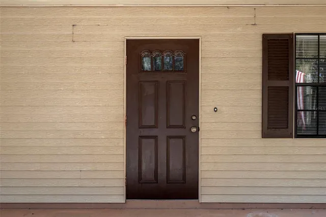 a view of an empty room with a fireplace and a window