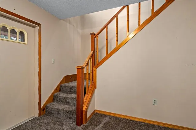 a view of an empty room with window and chandelier fan