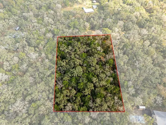 an aerial view of a house with a yard basket ball court and outdoor seating