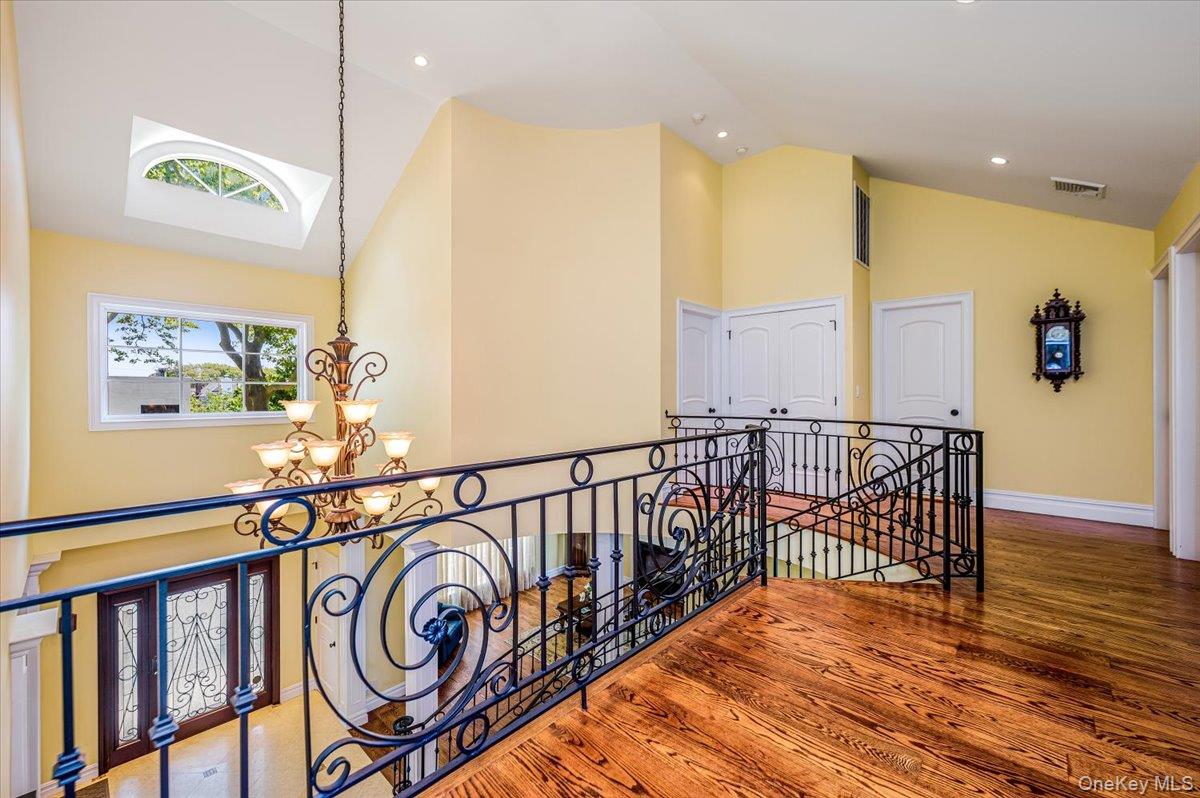 83 Ithaca Avenue Atlantic Beach, NY 11509 - Photo 19 of 45 Hall featuring an upstairs landing, high vaulted ceiling, a chandelier, wood finished floors, and recessed lighting