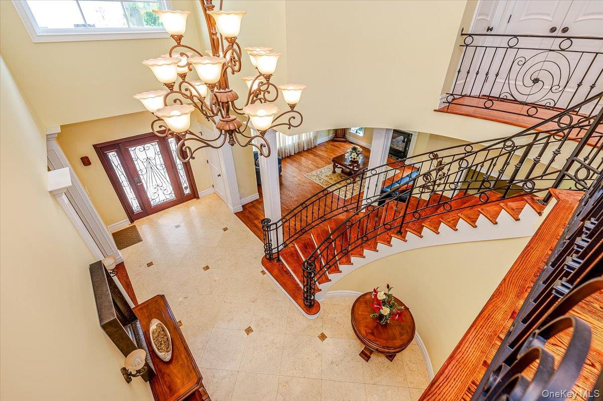 83 Ithaca Avenue Atlantic Beach, NY 11509 - Photo 6 of 45 Foyer entrance with a chandelier, a high ceiling, stairway, and tile patterned floors