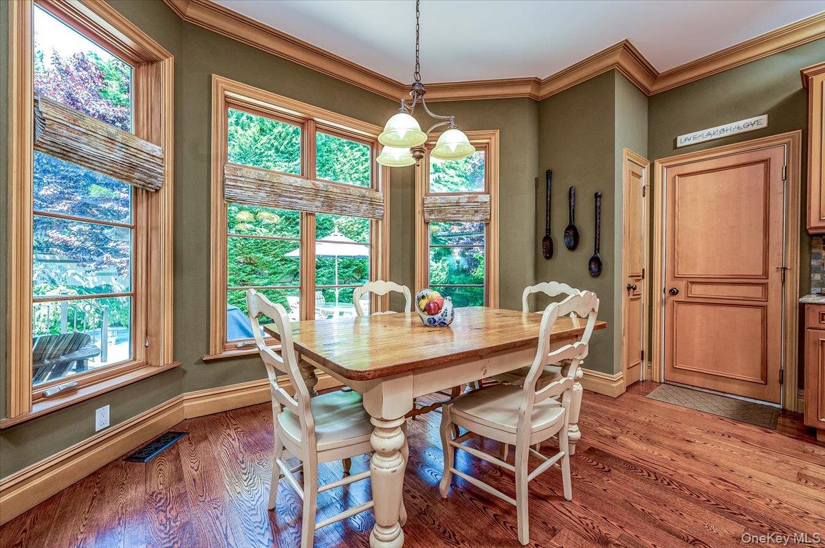83 Ithaca Avenue Atlantic Beach, NY 11509 - Photo 10 of 45 Dining space featuring light wood flooring, plenty of natural light, crown molding, and a chandelier