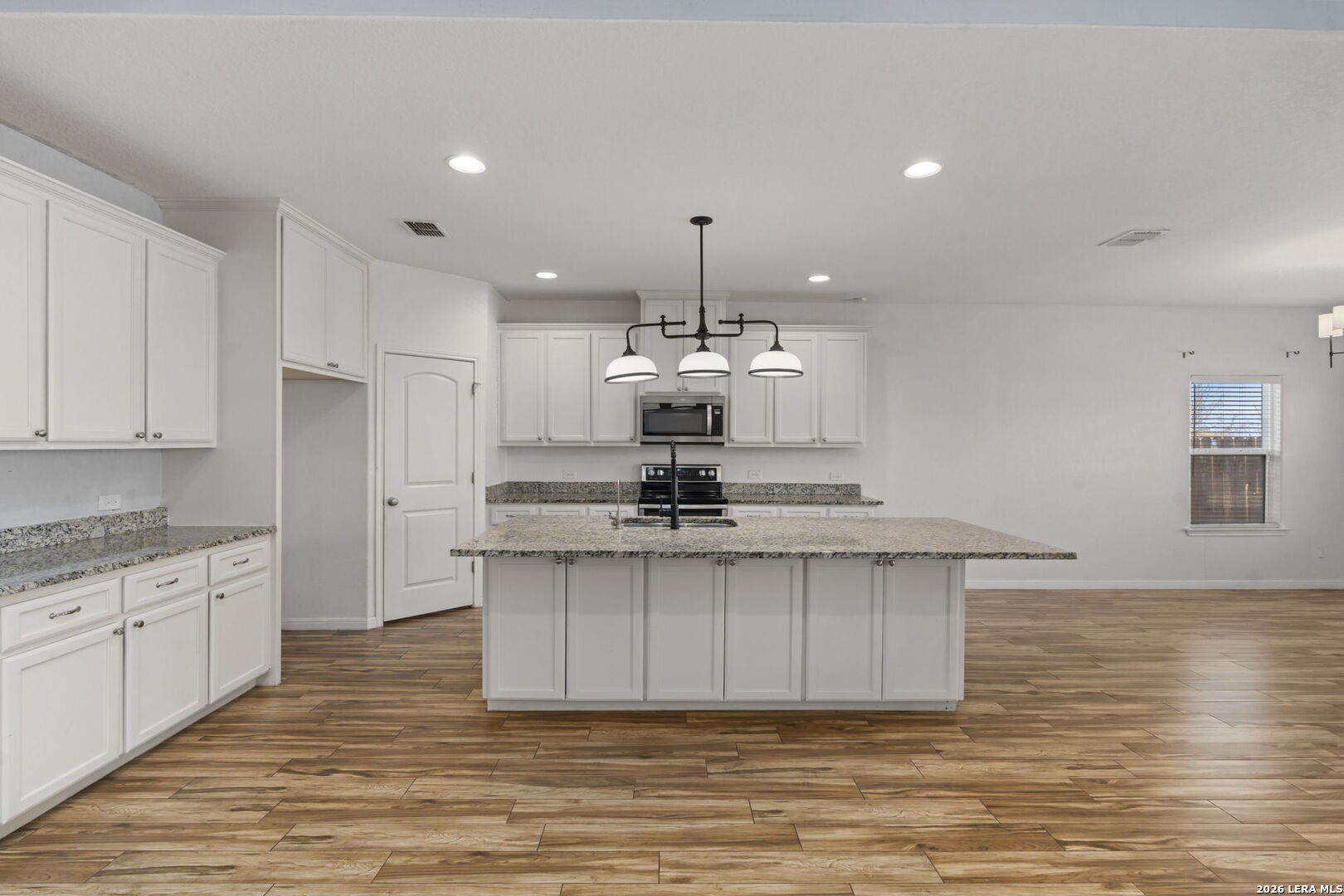162 Lost Maples Way Marion, TX 78124 - Photo 5 of 18 a view of a kitchen with kitchen island stainless steel appliances wooden floor and living room view