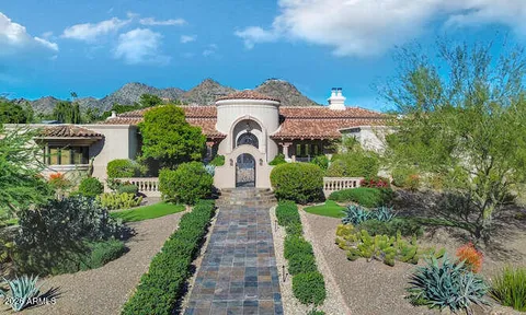 a front view of a house with a yard and fountain