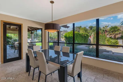 a dining room with furniture water view and a floor to ceiling window