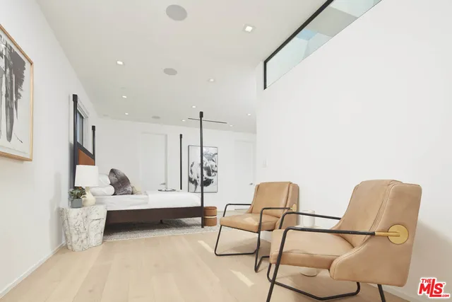 a bedroom with a bed a couch and potted plant