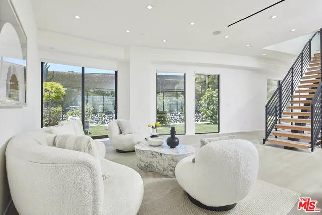 a large kitchen with a large counter top a sink stainless steel appliances and cabinets