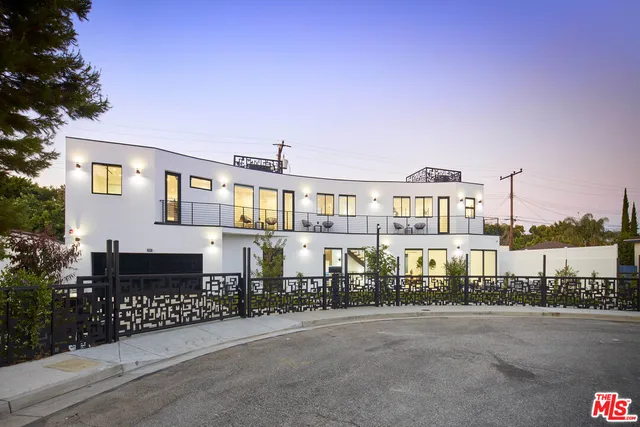 a roof deck with table and chairs and potted plants