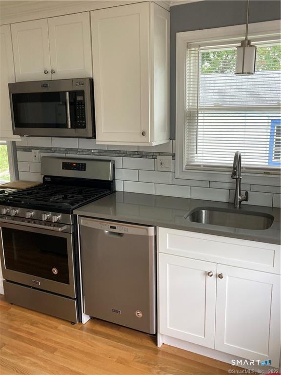 50 Short Beach Road Branford, CT 06405 - Photo 7 of 15 a kitchen with stainless steel appliances a stove microwave and sink