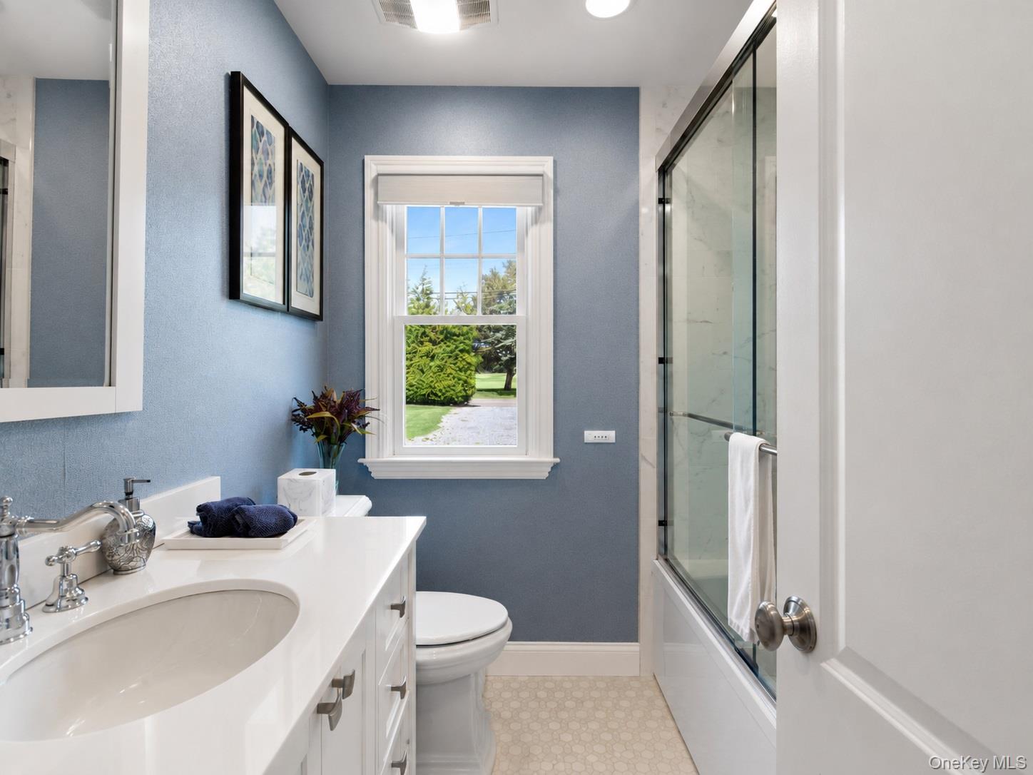 65 Shore Road Westhampton, NY 11977 - Photo 19 of 24 Bathroom featuring a single vanity with a white countertop and undermount sink, chrome faucet, and white cabinetry