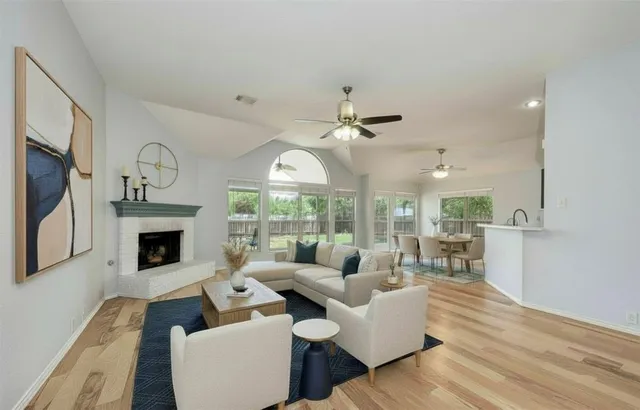 a living room with furniture a fireplace and a large window