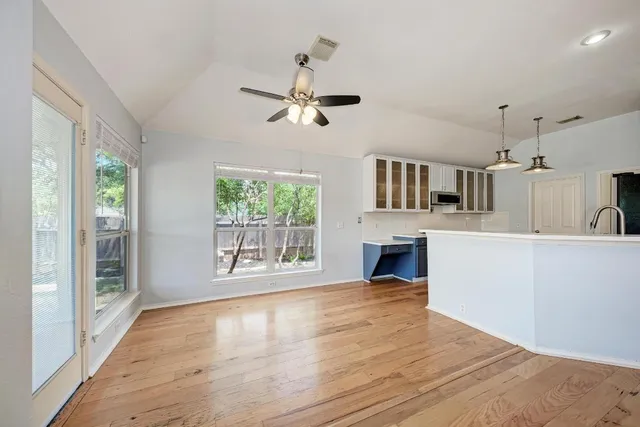 a large kitchen with stainless steel appliances a large counter top a stove a chimney a sink and a refrigerator