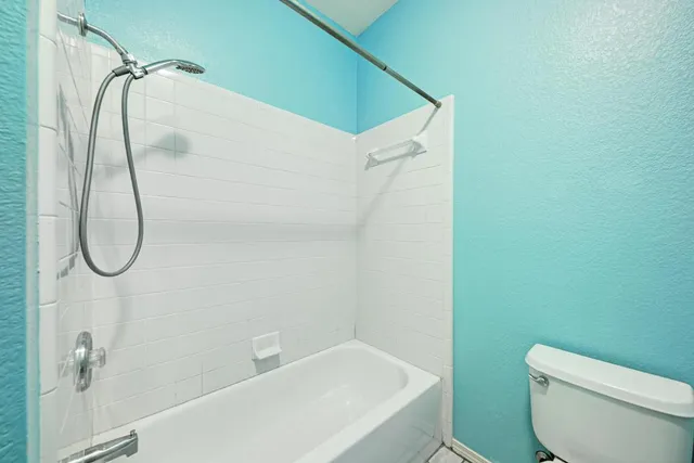 a view of an empty room with wooden floor and closet