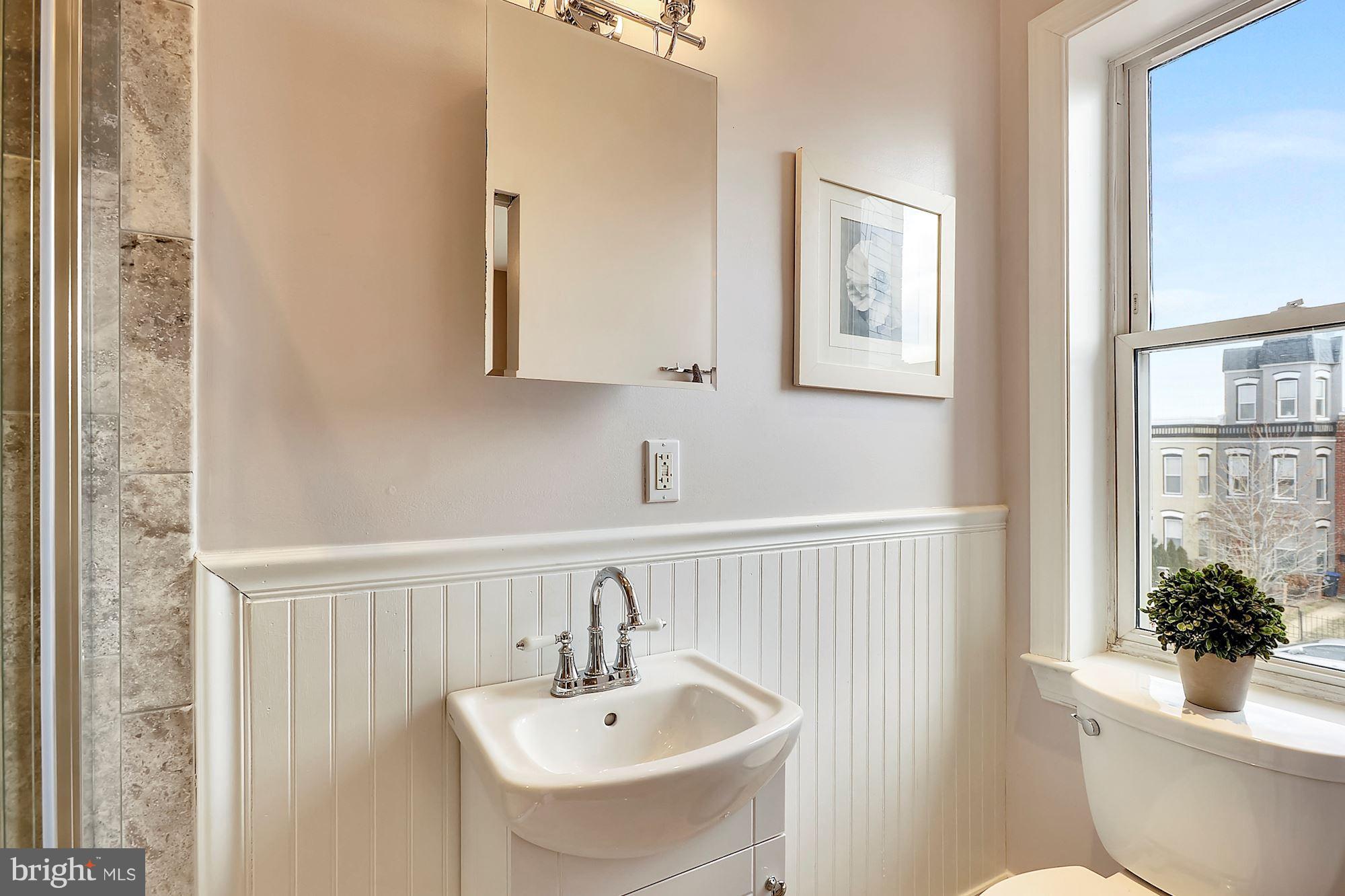 818 12th Street Northeast Washington, DC 20002 - Photo 19 of 29 a bathroom with a sink and mirror with toilet