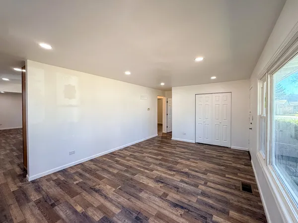 a view of empty room with wooden floor