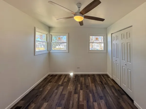 a view of an empty room and wooden floor and a window