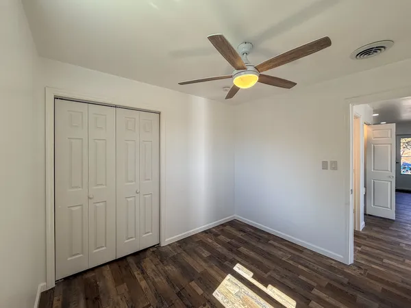 a view of a hallway with wooden floor and a cabinet