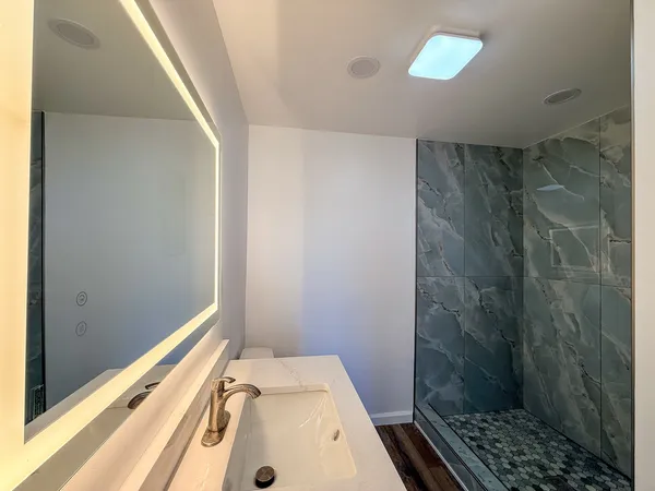 a bathroom with a sink a toilet and shower