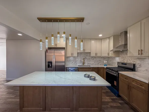a view of kitchen with stainless steel appliances granite countertop a refrigerator a sink and a stove