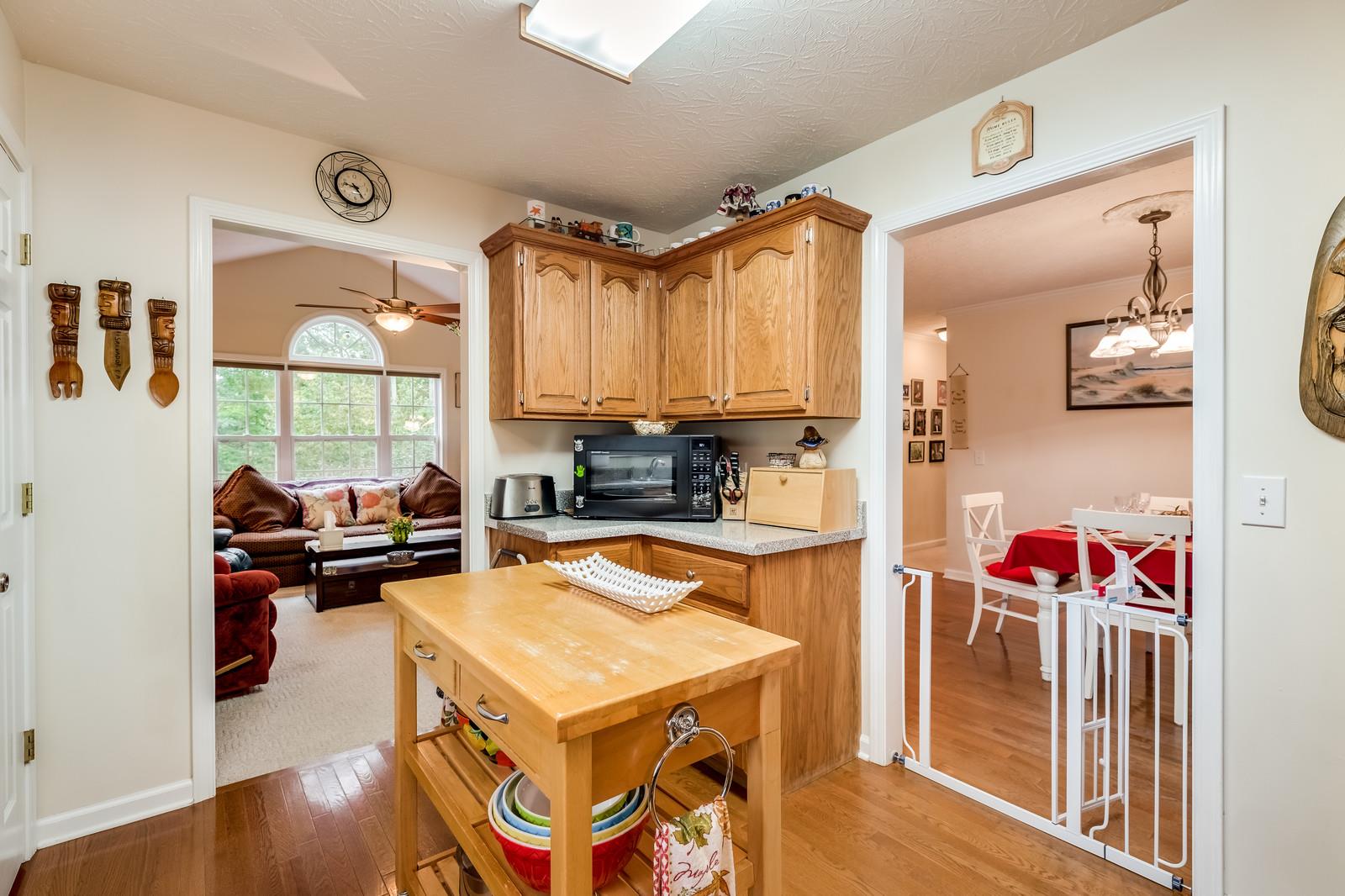 1529 Rapids Road Portland, TN 37148 - Photo 24 of 30 a kitchen with a refrigerator a stove a sink dishwasher and a dining table with wooden floor