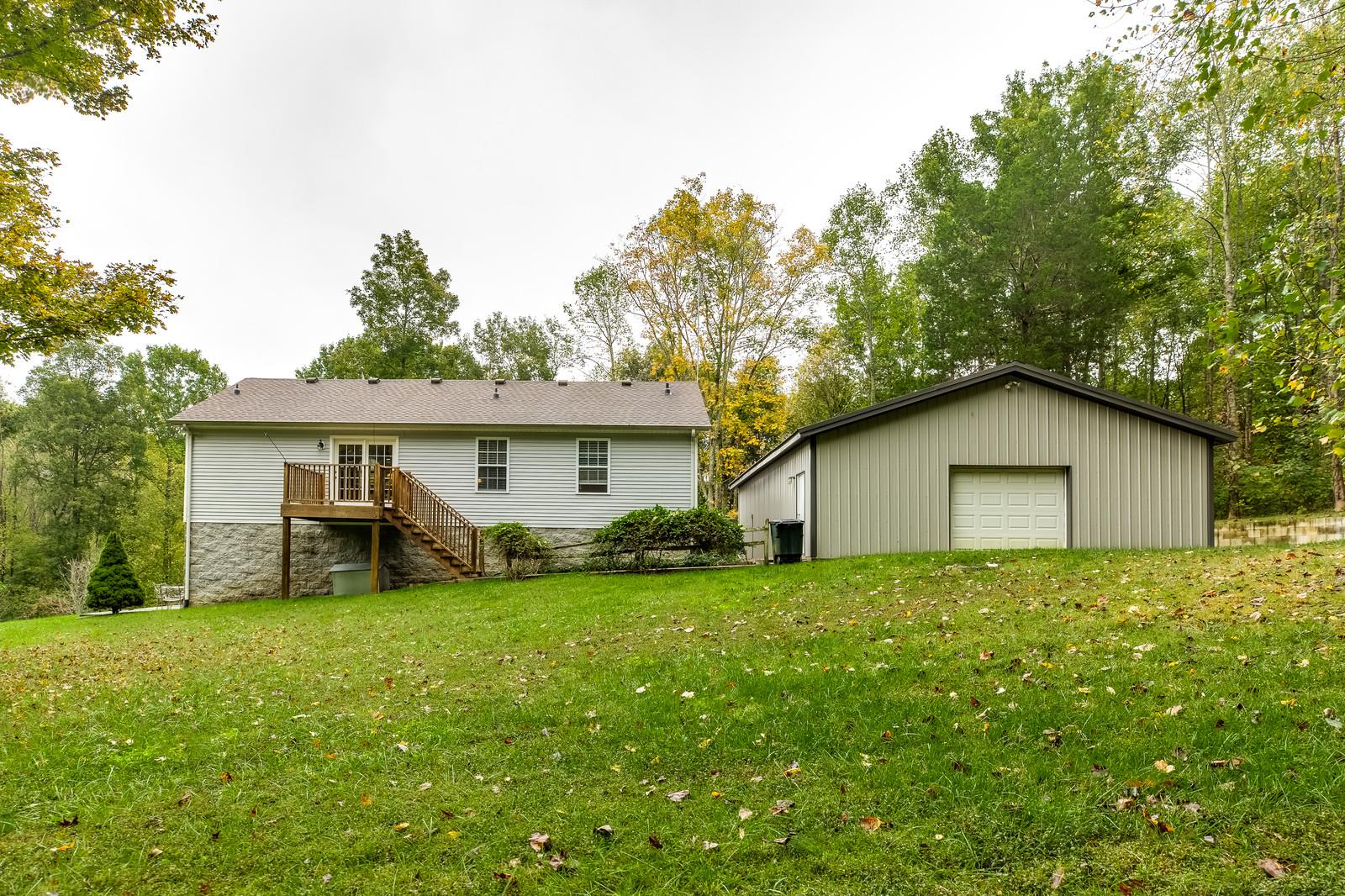 1529 Rapids Road Portland, TN 37148 - Photo 5 of 30 a house that is sitting in the grass with large trees