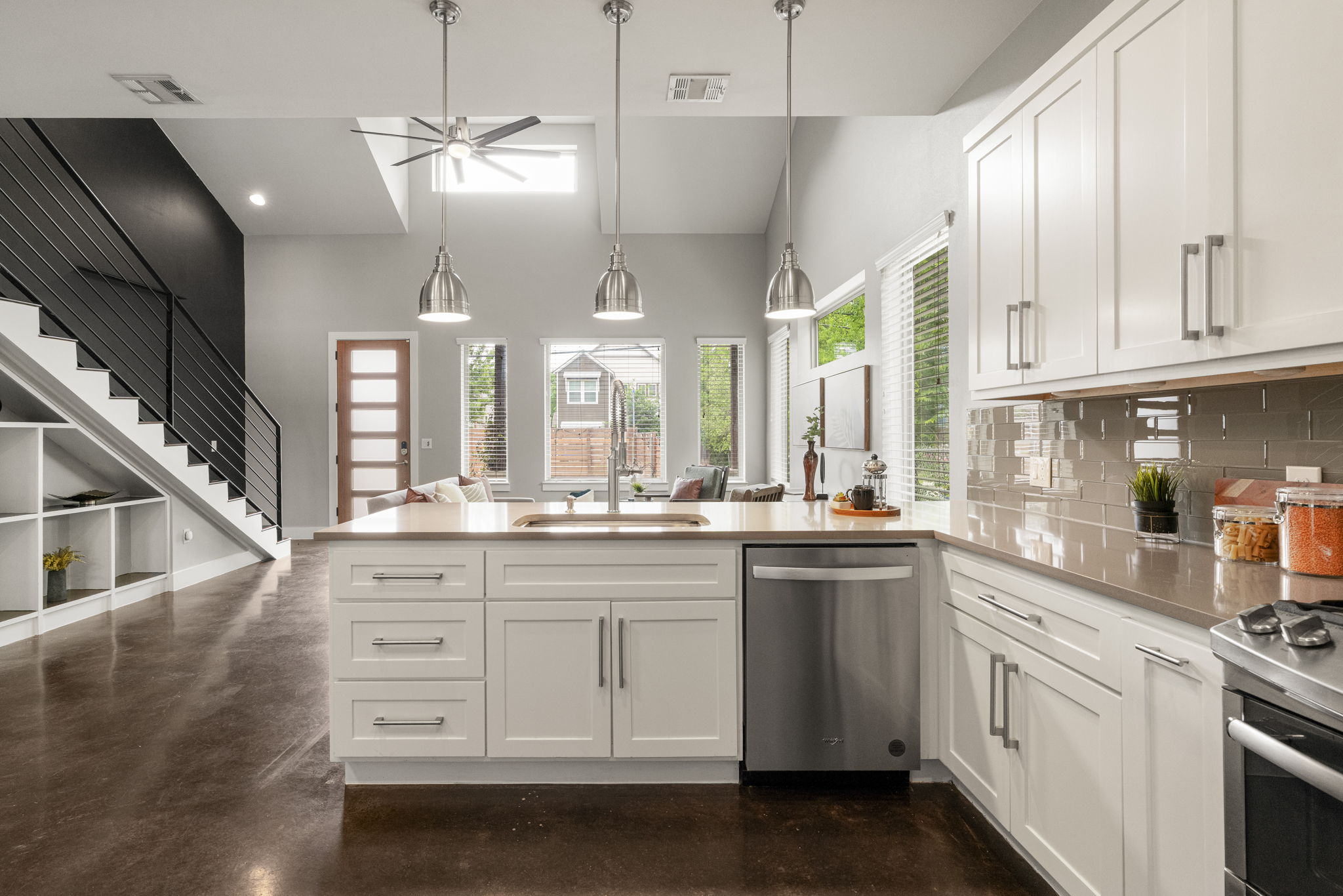 5204 Samuel Huston Avenue, Unit A Austin, TX 78721 - Photo 15 of 38 Open-concept kitchen featuring white cabinetry, stainless steel appliances, and a tiled backsplash