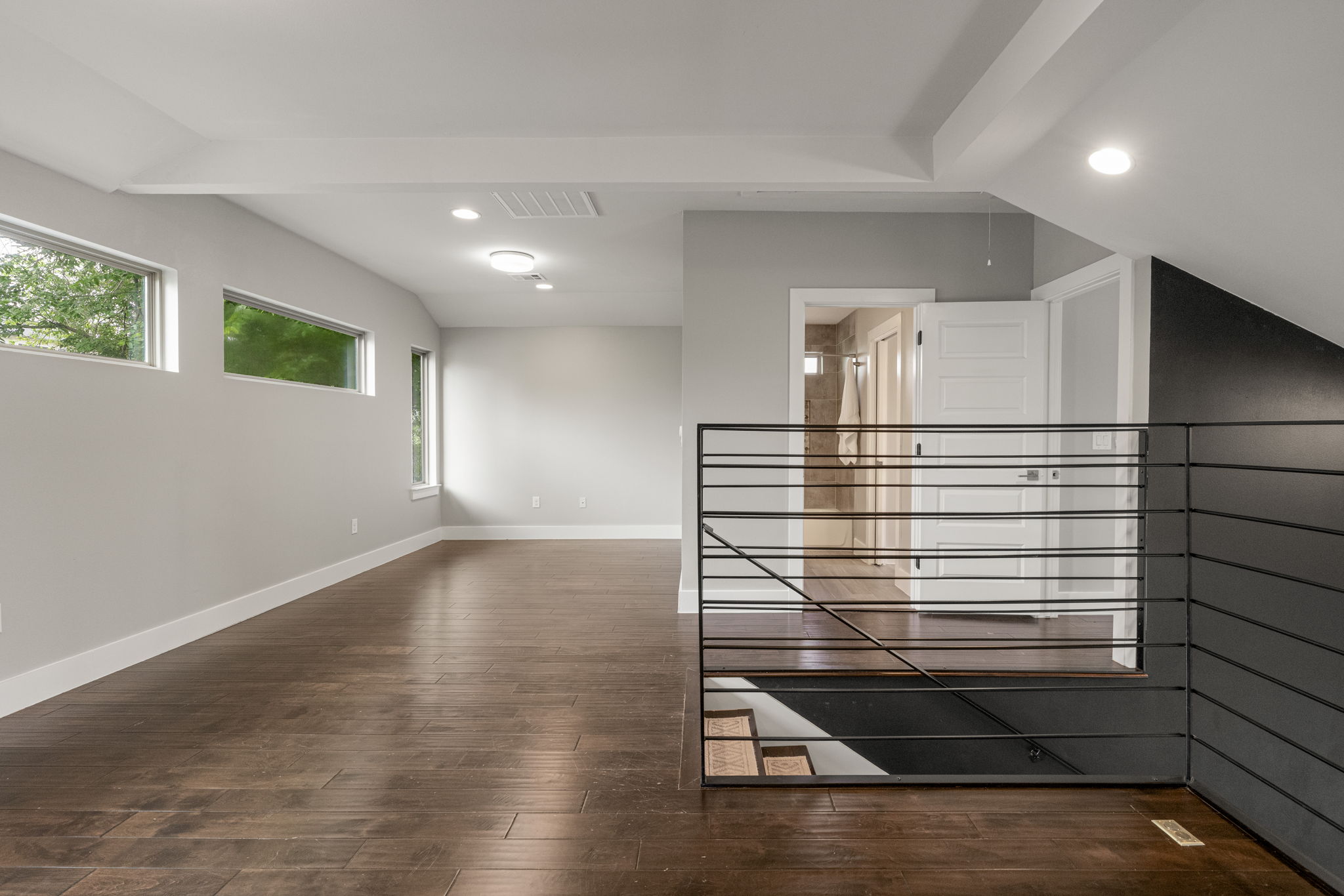 5204 Samuel Huston Avenue, Unit A Austin, TX 78721 - Photo 27 of 38 Spacious room featuring rich wood-finish flooring, recessed lighting, and multiple horizontal windows