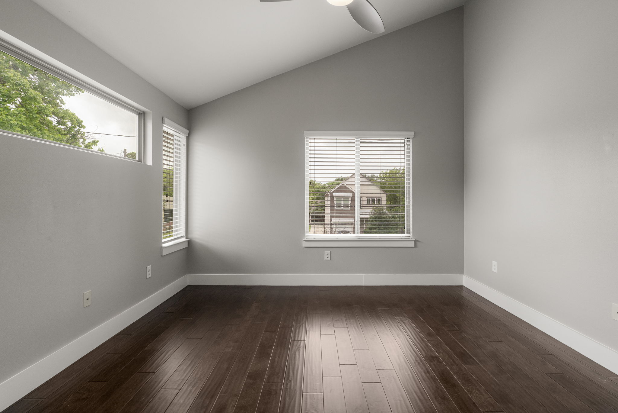 5204 Samuel Huston Avenue, Unit A Austin, TX 78721 - Photo 28 of 38 Vaulted ceiling room featuring rich wood-finish flooring, multiple windows with blinds, and a ceiling fan