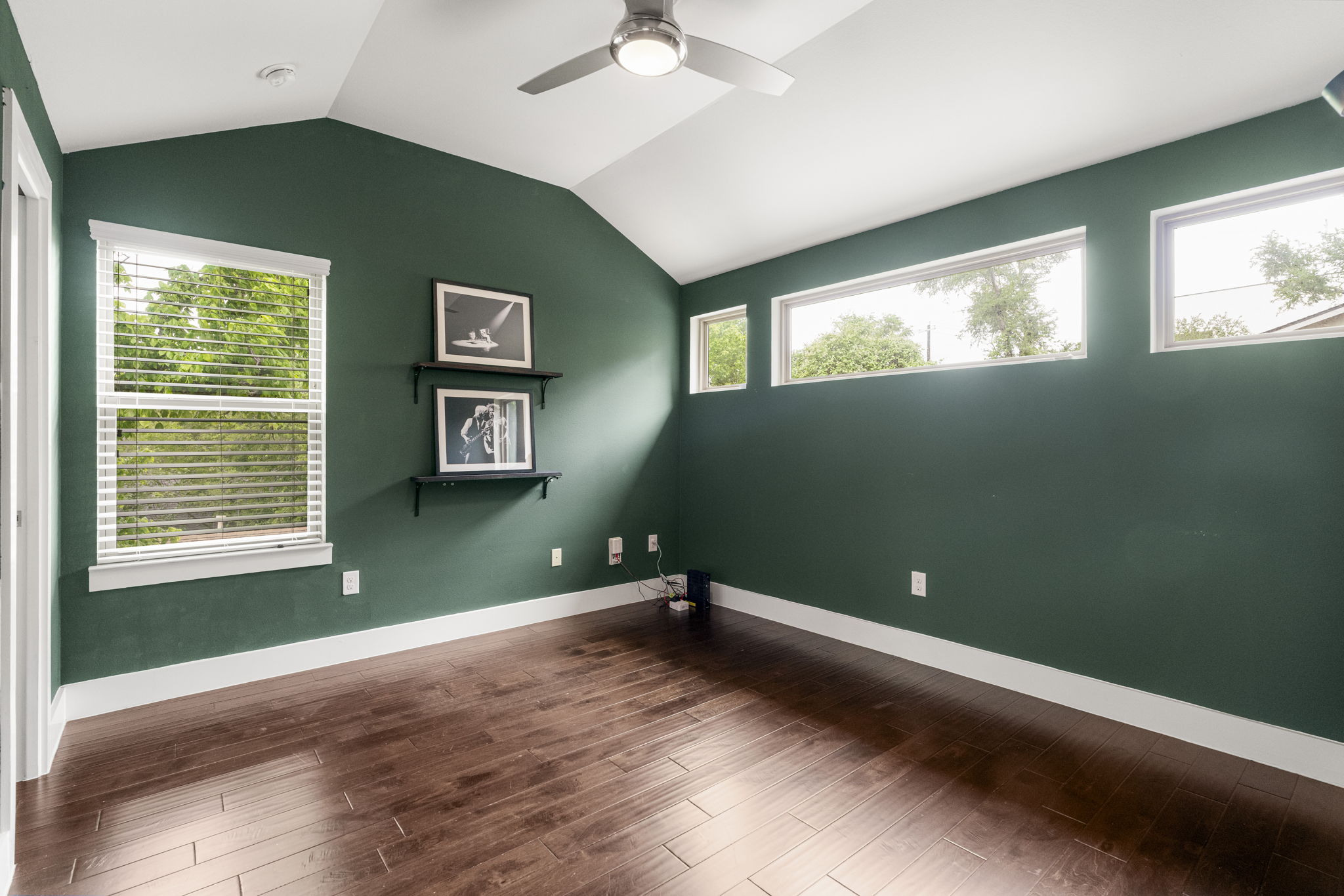 5204 Samuel Huston Avenue, Unit A Austin, TX 78721 - Photo 31 of 38 Room featuring rich emerald green walls, wood-finish flooring, a vaulted ceiling, and a contemporary ceiling fan