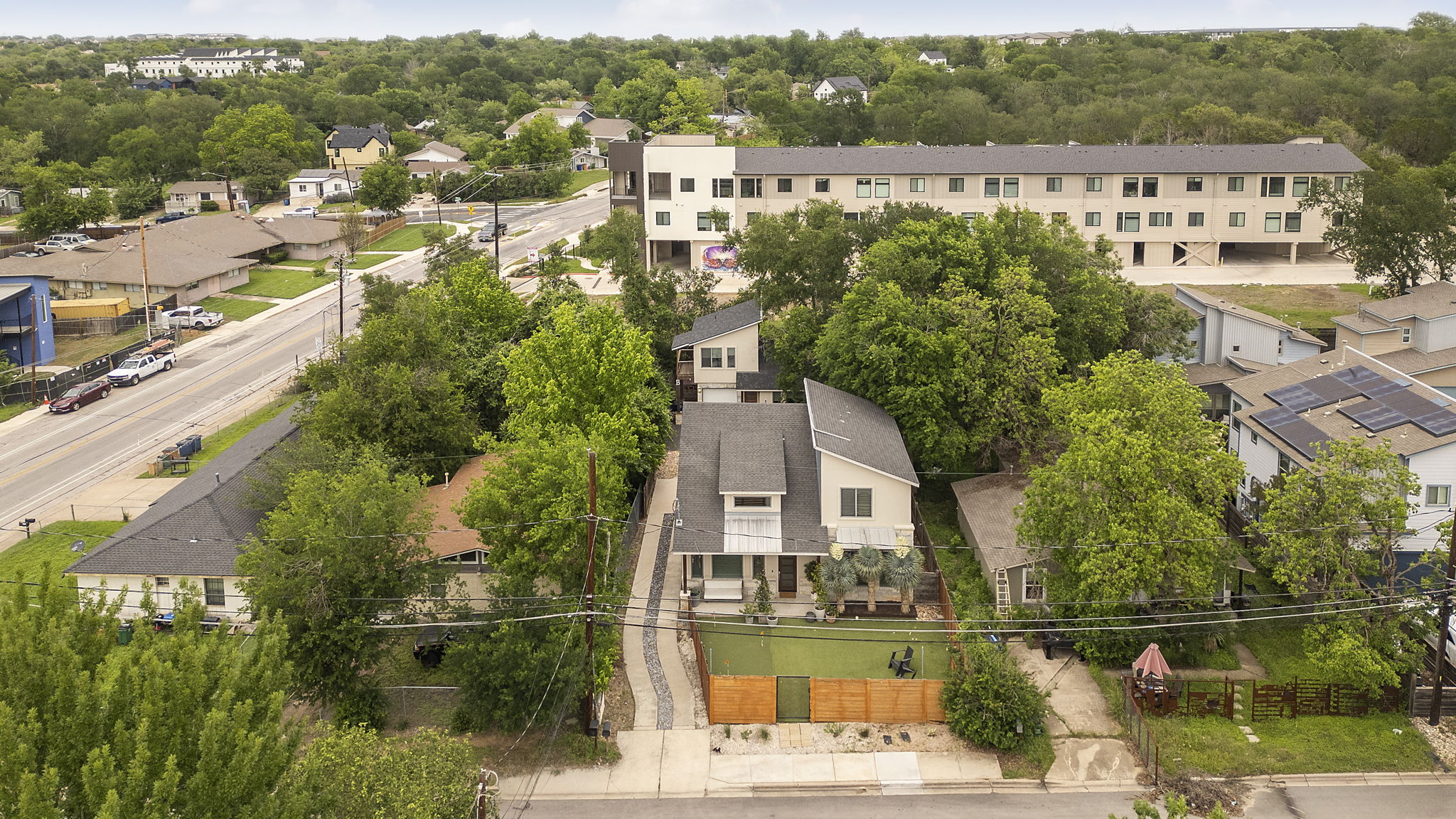 5204 Samuel Huston Avenue, Unit A Austin, TX 78721 - Photo 37 of 38 Contemporary residence featuring a light-colored facade, dark-pitched roof, and multiple windows