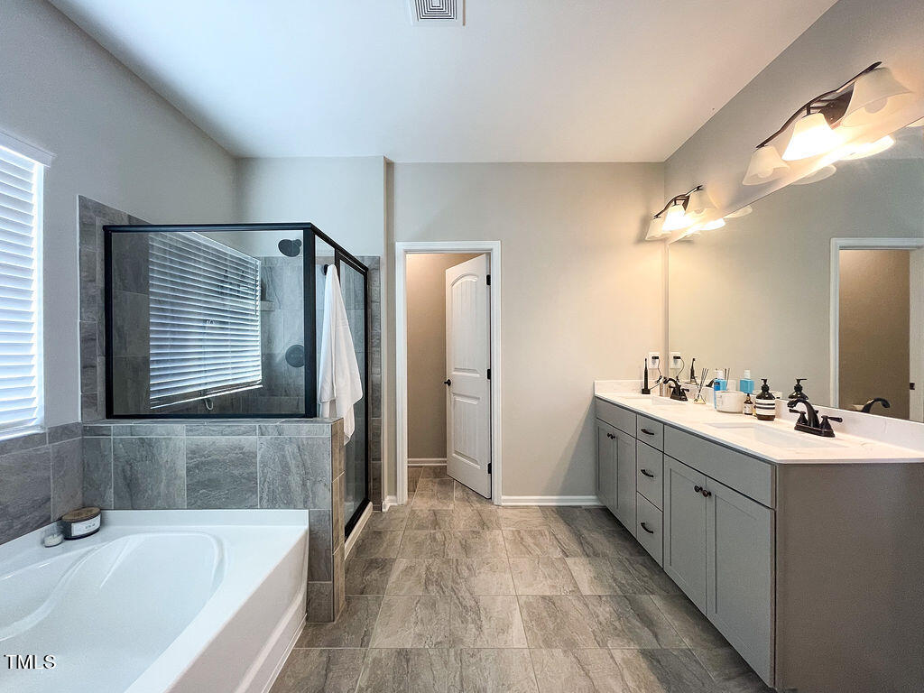 3604 Cross Timber Lane Raleigh, NC 27603 - Photo 11 of 15 a bathroom with a tub sink and mirror