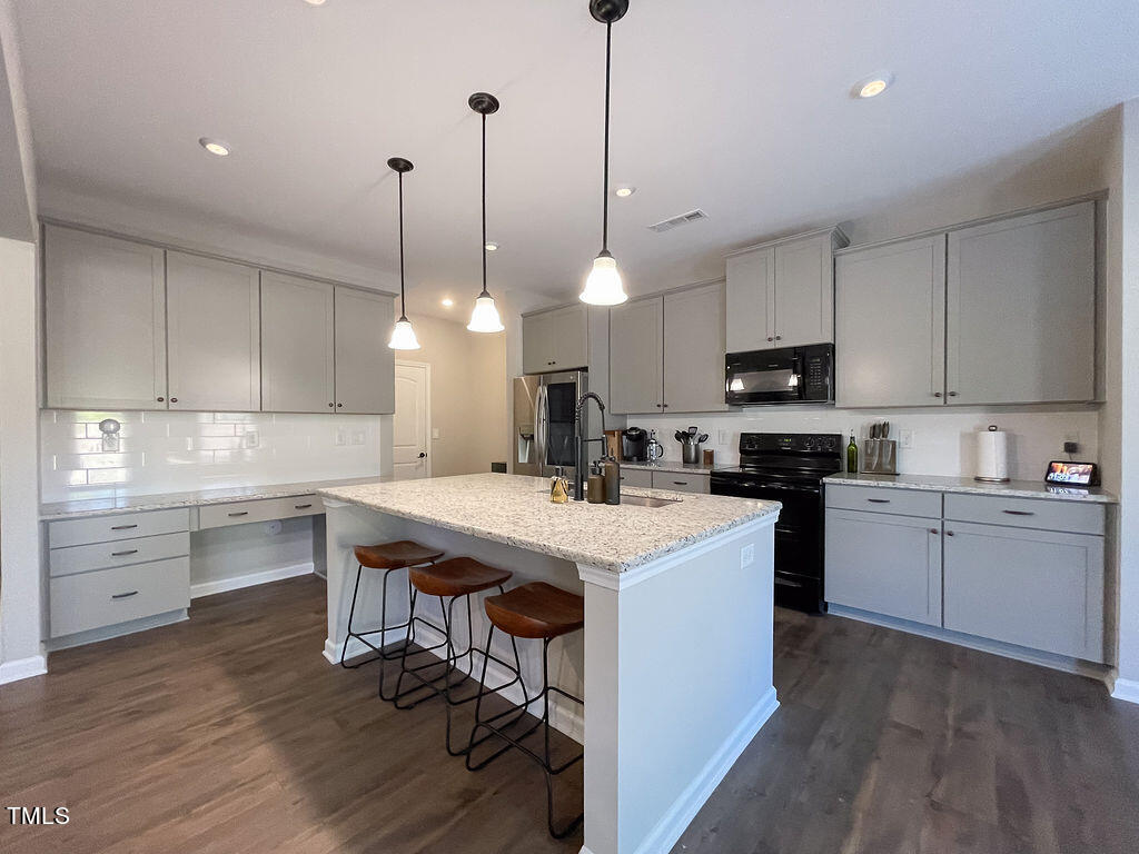 3604 Cross Timber Lane Raleigh, NC 27603 - Photo 2 of 15 a kitchen with kitchen island a sink a stove and a center island
