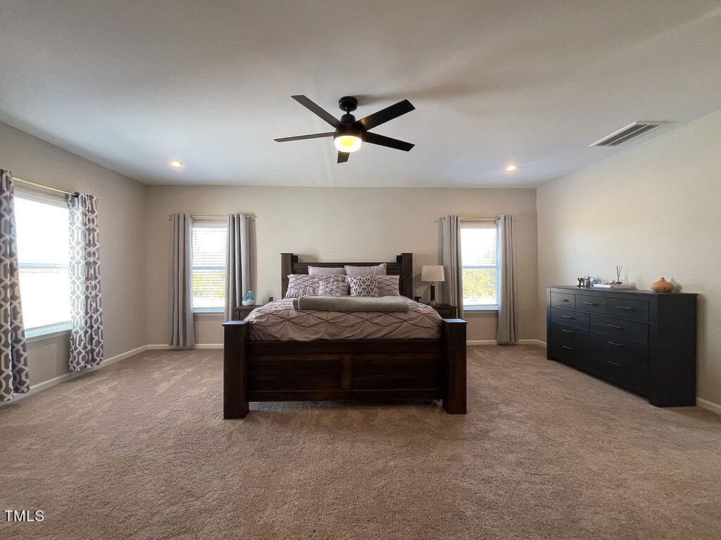 3604 Cross Timber Lane Raleigh, NC 27603 - Photo 8 of 15 a spacious bedroom with a bed and a chandelier